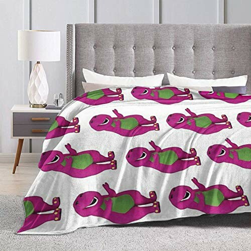 Bedroom with a blanket featuring a pattern of purple dinosaurs on a bed.